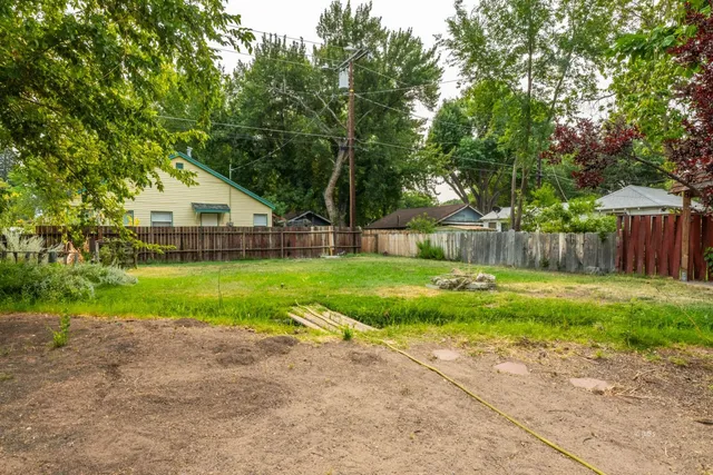 a backyard of a house with fountain table and chairs