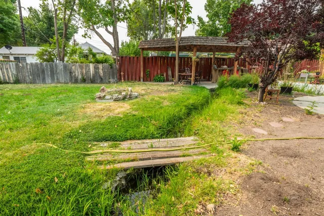a view of a yard with a house and large tree