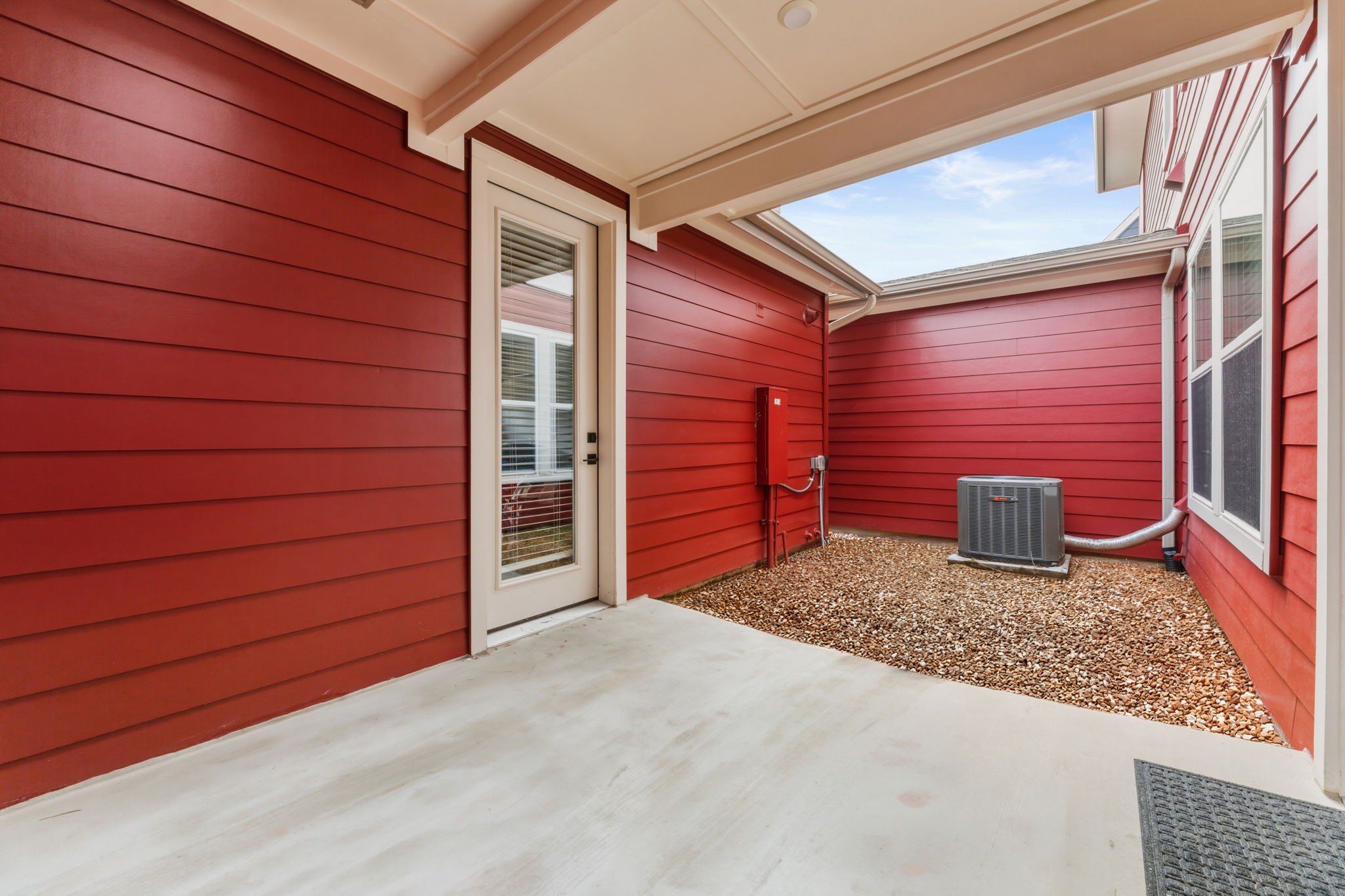 2929 Moreno Street Austin, TX 78723 - Photo 39 of 40 Concrete patio with a red horizontal siding exterior and white trim accents