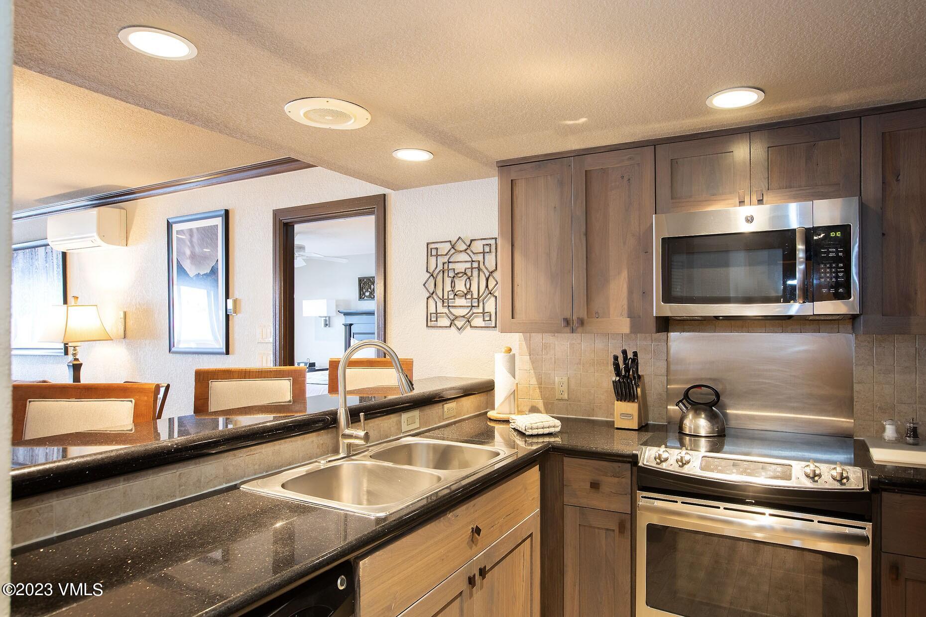 210 Offerson Road, Unit 208 WEEK 24 Beaver Creek, CO 81620 - Photo 7 of 27 a kitchen with a sink and a stove top oven with wooden floor