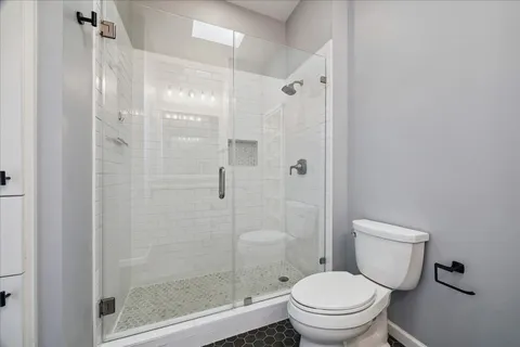 a white toilet next to a bathroom