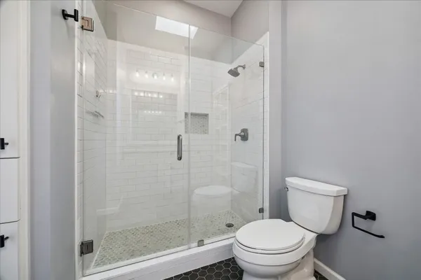 a white toilet next to a bathroom
