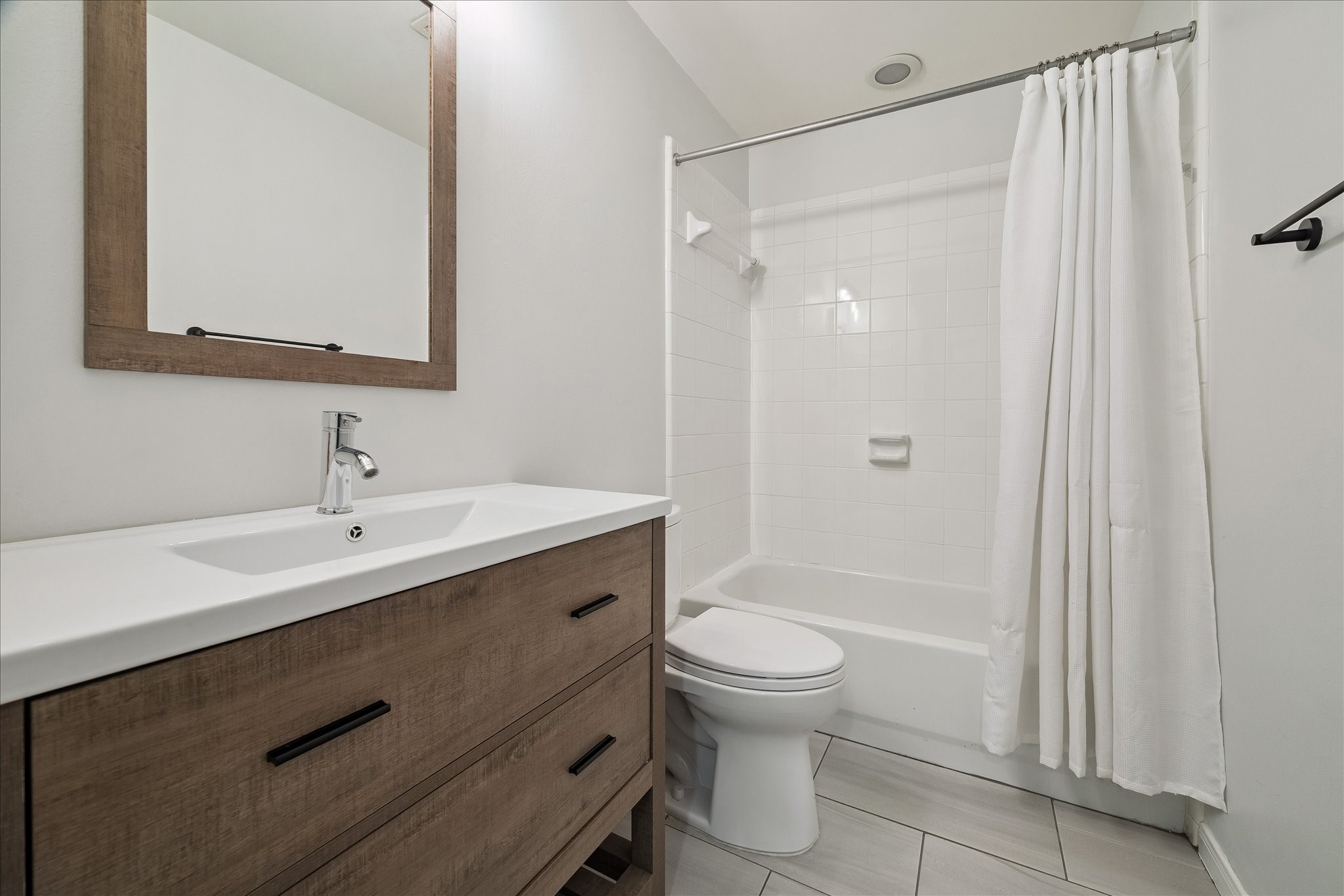 3001 Austin Street Houston, TX 77004 - Photo 17 of 26 Updated full bath has large counter space, tub/shower combo, and large format tile flooring.