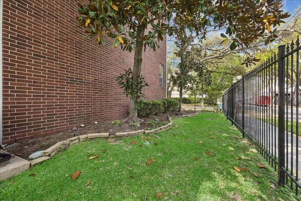 a view of a backyard with brick wall and potted plants