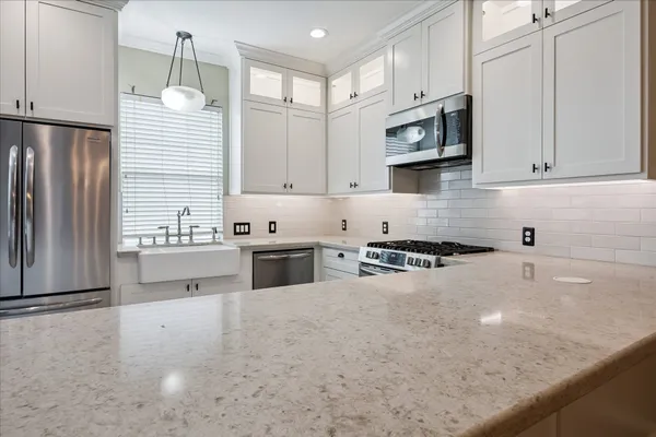 a kitchen with stainless steel appliances granite countertop a sink a stove and a refrigerator
