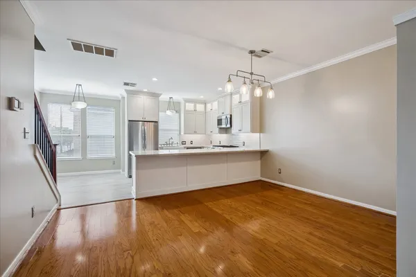 a large white kitchen with a refrigerator a sink dishwasher and a fireplace with wooden floor