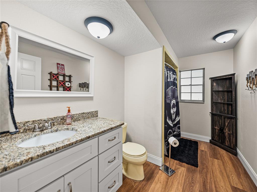 609 West Pipkin Road Lakeland, FL 33813 - Photo 32 of 72 a bathroom with a granite countertop sink a toilet and a window