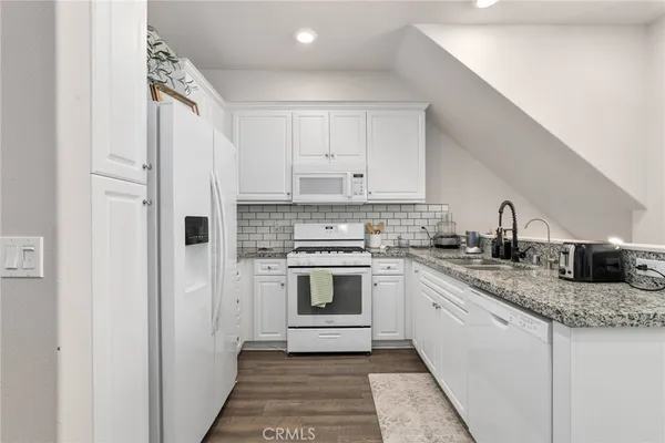 a kitchen with stainless steel appliances granite countertop a sink and cabinets