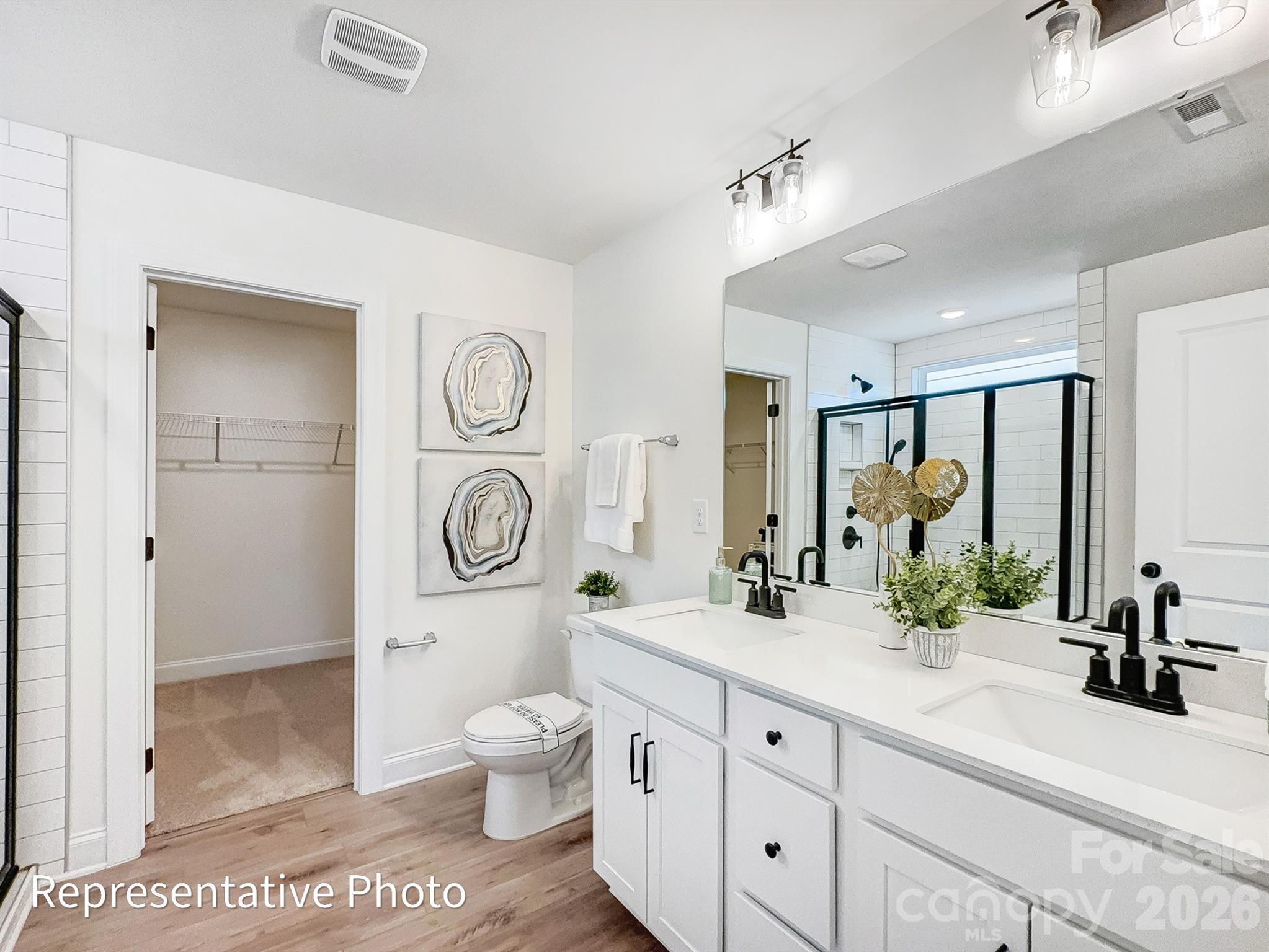 2608 Wild Azalea Court Monroe, NC 28110 - Photo 19 of 26 a spacious bathroom with a toilet a sink and a large mirror