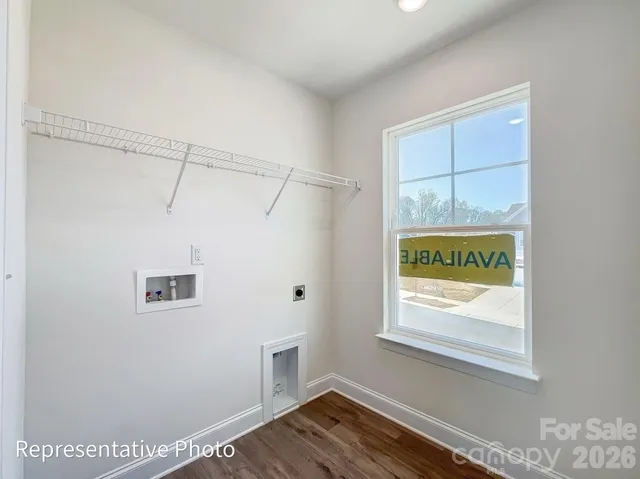 a view of a hallway with wooden floor and a window
