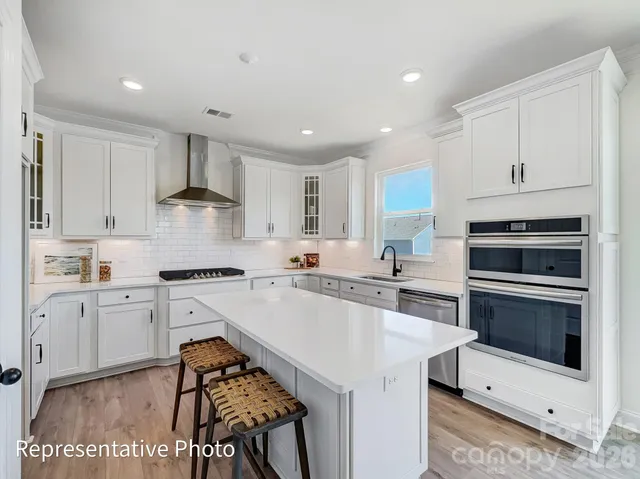a kitchen with granite countertop white cabinets and white appliances