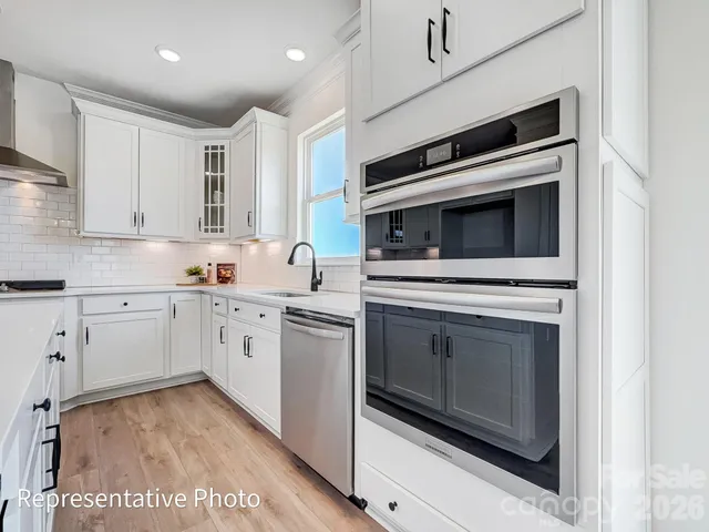 a kitchen with granite countertop cabinets stainless steel appliances and a counter space