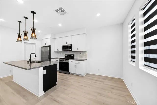 a kitchen with stainless steel appliances granite countertop a sink stove and refrigerator