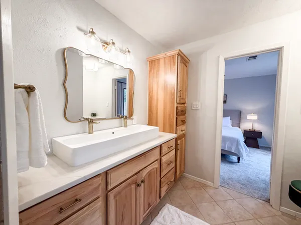 a en suite bathroom with a double vanity sink and a mirror