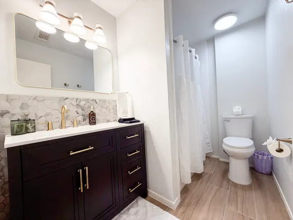 a bathroom with a sink a toilet and mirror