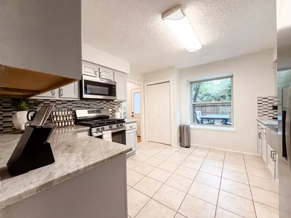 a kitchen with stainless steel appliances a stove a sink and a microwave