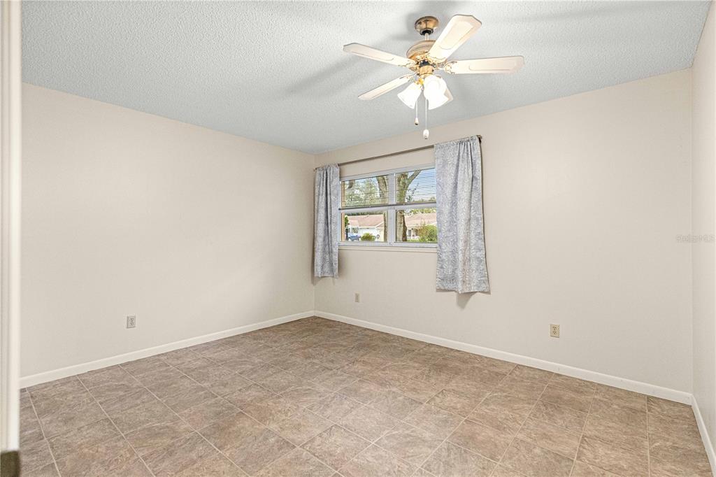 8665 Southwest 94 Street, Unit C Ocala, FL 34481 - Photo 16 of 29 an empty room with windows and ceiling fan
