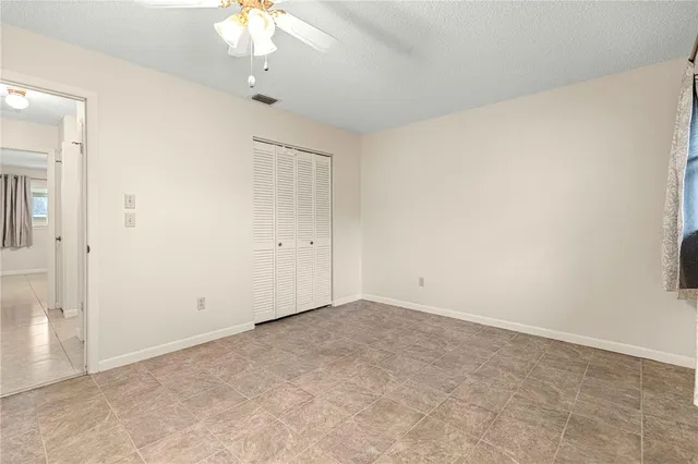an empty room with a chandelier fan