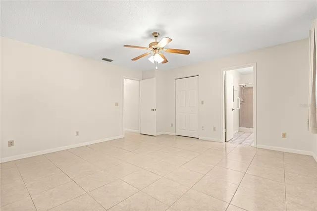 an empty room with closet and fan