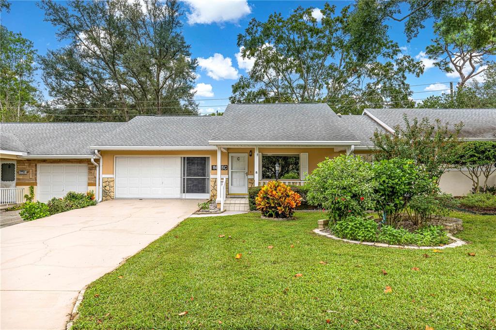 8665 Southwest 94 Street, Unit C Ocala, FL 34481 - Photo 29 of 29 a front view of a house with a garden and trees