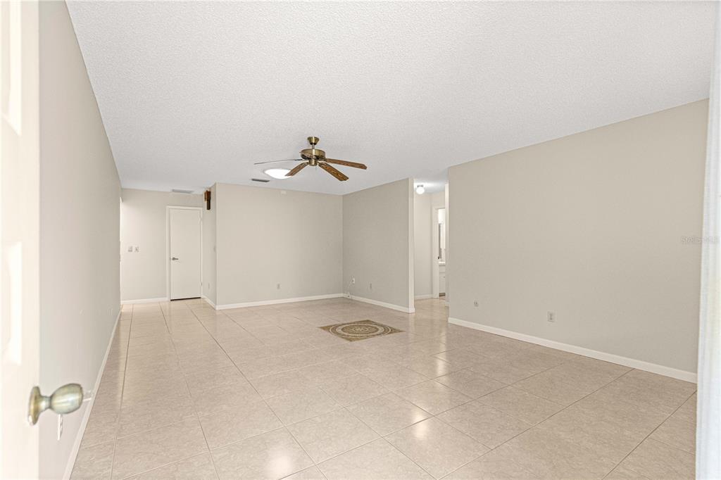8665 Southwest 94 Street, Unit C Ocala, FL 34481 - Photo 3 of 29 an empty room with a chandelier fan and windows