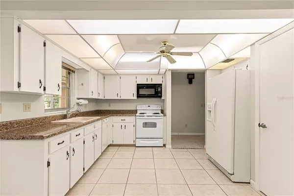 a kitchen with stainless steel appliances granite countertop a refrigerator and a stove top oven