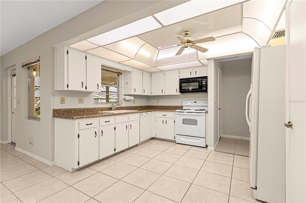 8665 Southwest 94 Street, Unit C Ocala, FL 34481 - Photo 9 of 29 a kitchen with granite countertop white cabinets and white appliances