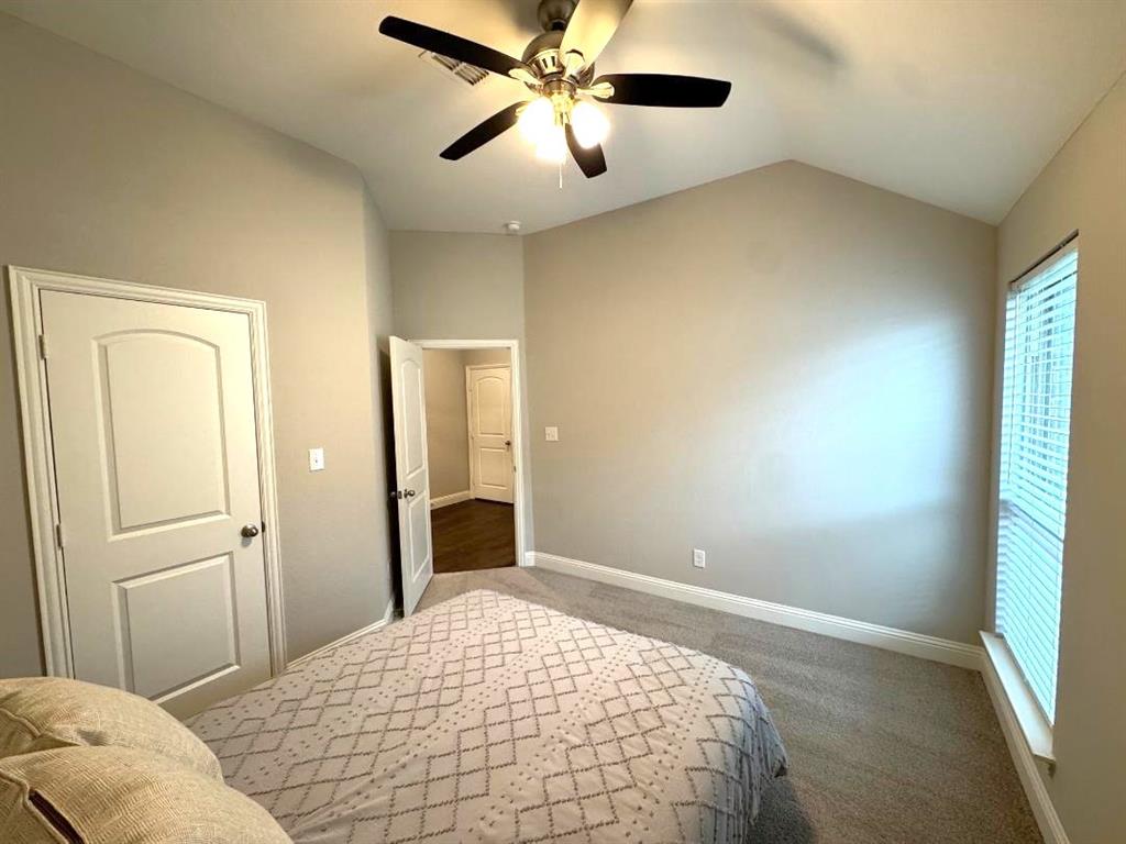 1455 Radecke Road Krum, TX 76249 - Photo 15 of 18 a bedroom with a bed and a chandelier