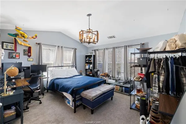 a bedroom with bed and a chandelier