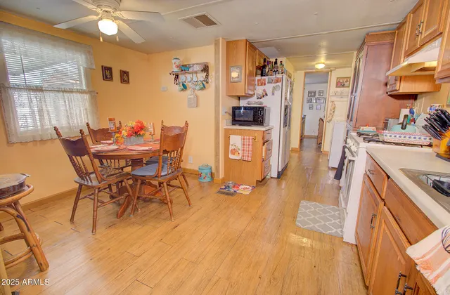 a dining hall with stainless steel appliances a dining table and chairs with wooden floor