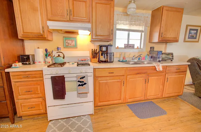 a kitchen with stainless steel appliances granite countertop a sink a stove and cabinets