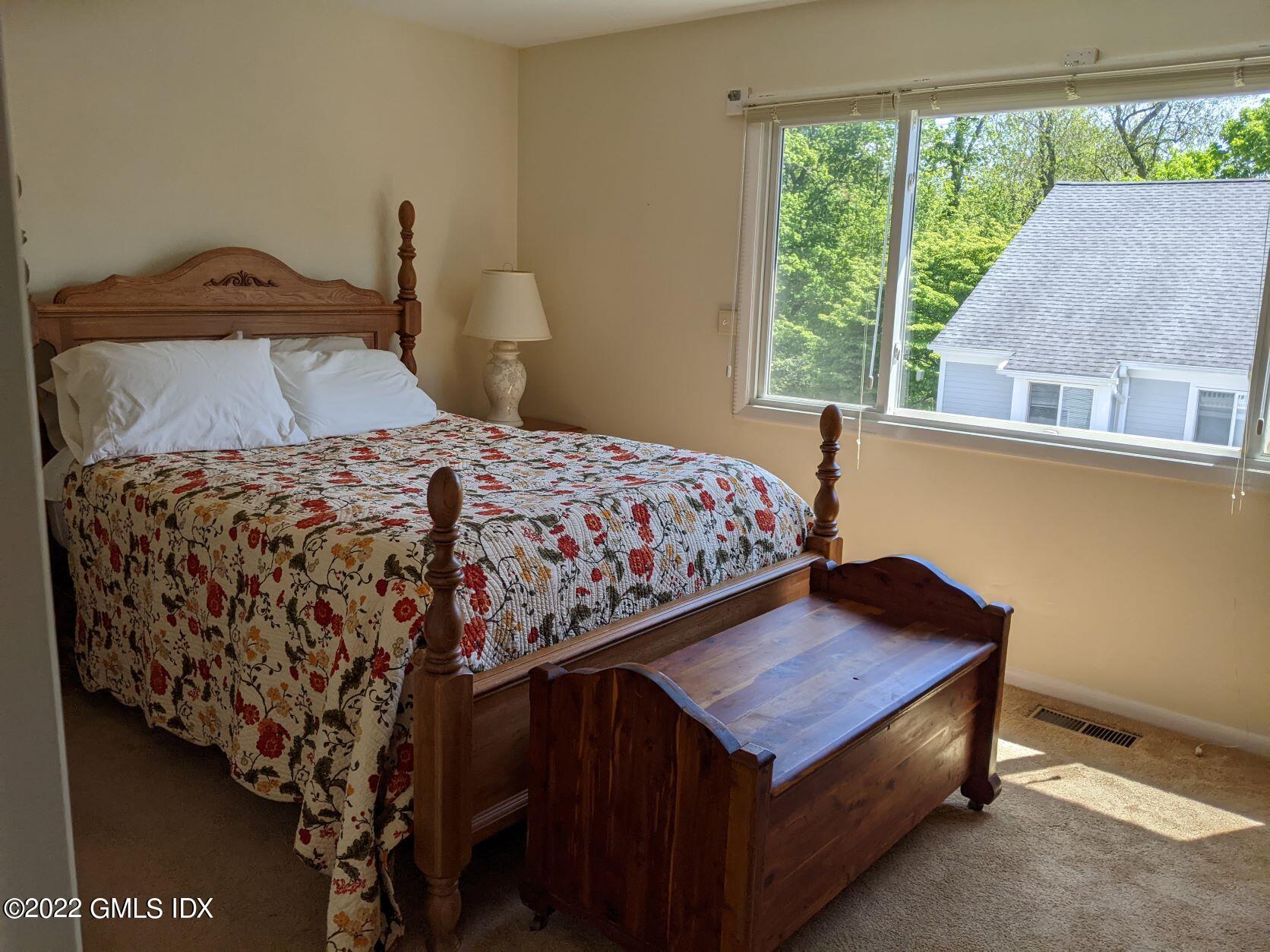 63 Stirrup Lane, Unit 63 Riverside, CT 06878 - Photo 15 of 21 a bedroom with a bed and a window