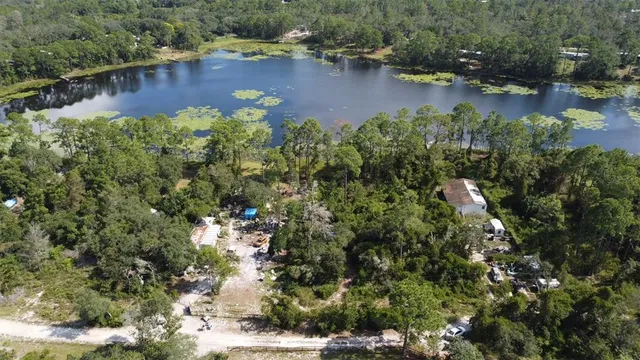 an aerial view of residential houses with outdoor space and lake view