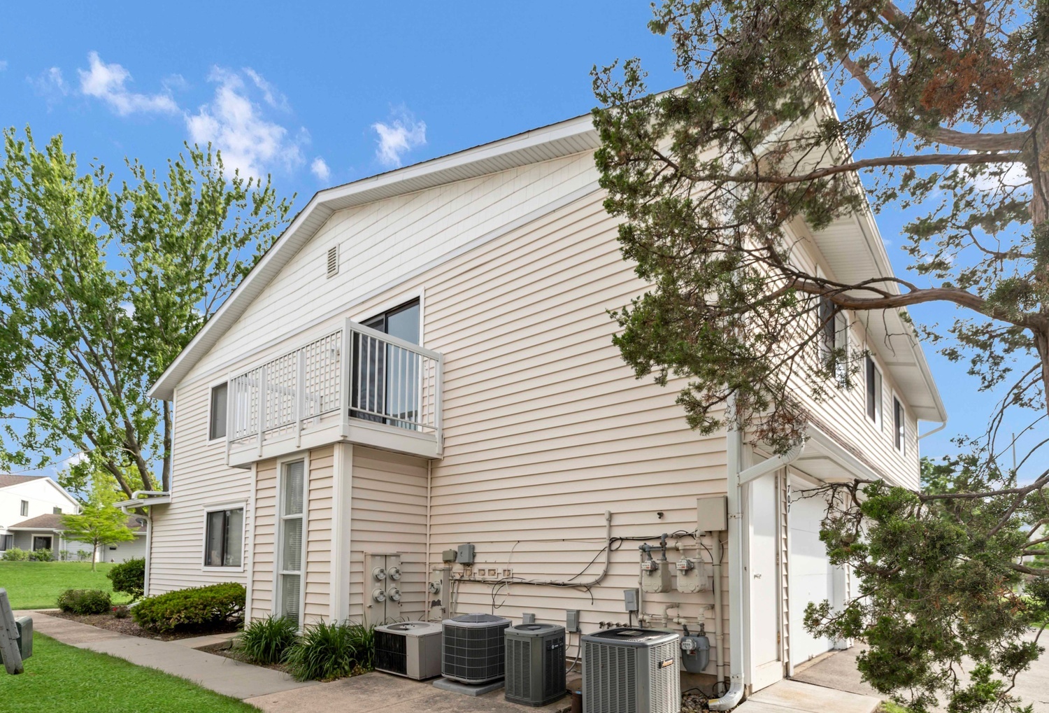 707 Sunfish Point, Unit 707 Schaumburg, IL 60194 - Photo 2 of 20 a view of a white house with a large tree and plants