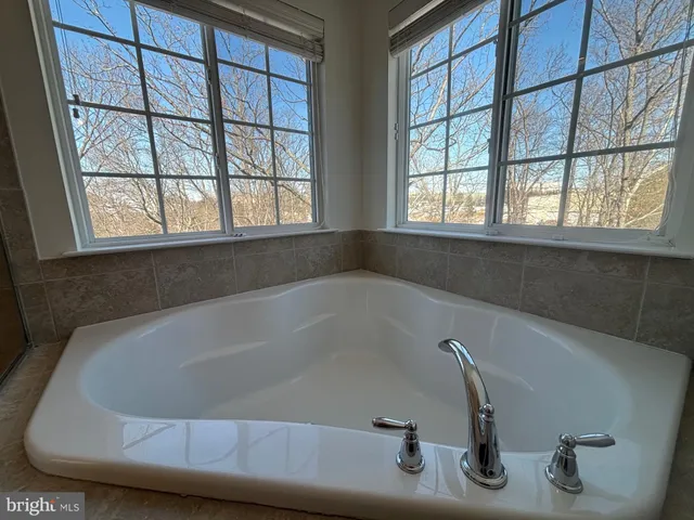 a bath tub sitting in a bathroom next to a window