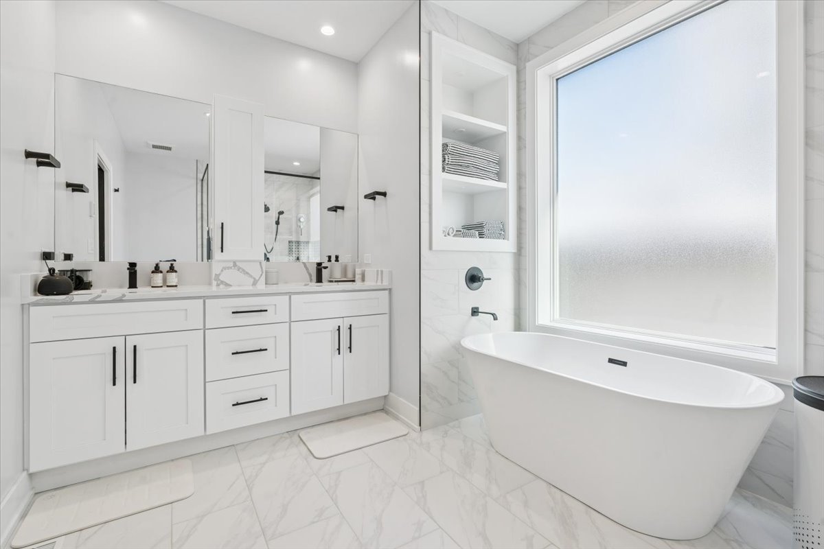 Undisclosed Address Chicago, IL 60630 - Photo 19 of 26 a spacious bathroom with a double vanity sink a mirror and a bathtub