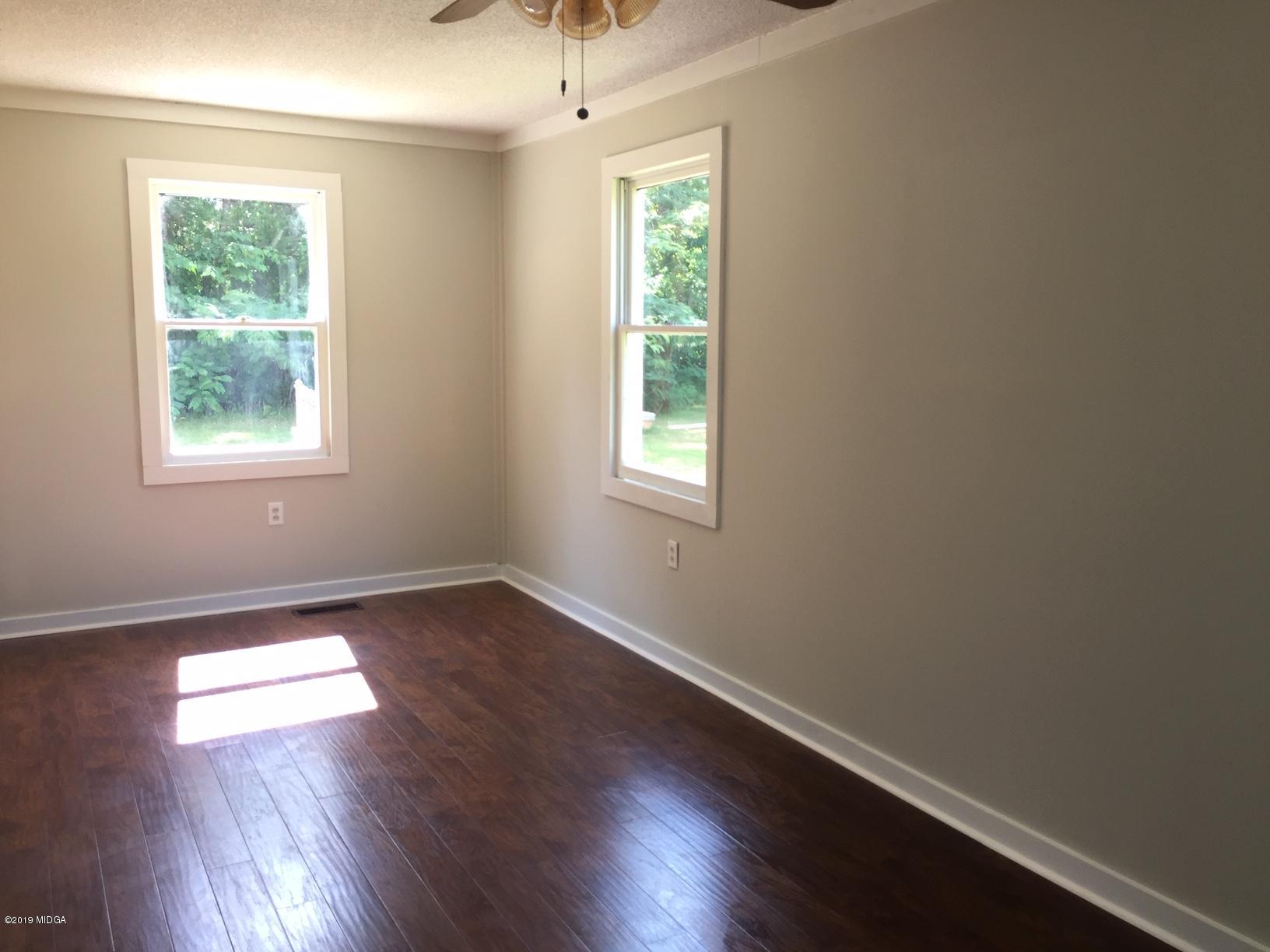 265 Hickman Road Forsyth, GA 31029 - Photo 14 of 16 an empty room with wooden floor and windows