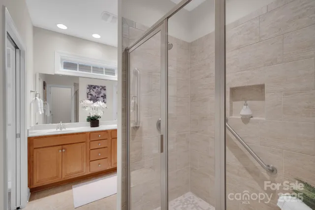 a bathroom with a double vanity sink a toilet and shower