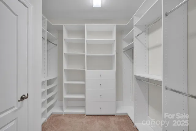 a view of walk in closet with empty racks