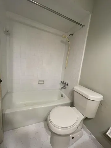 a white toilet sitting next to a bath tub