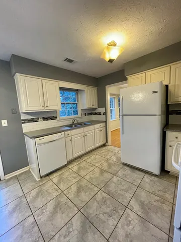 a kitchen with a refrigerator a stove top oven and a sink