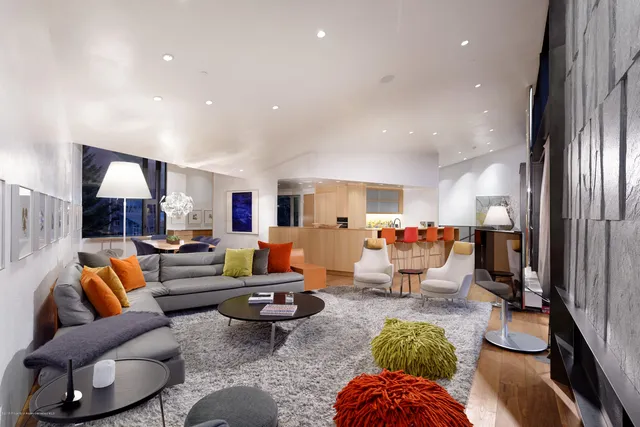 a living room with furniture and a view of kitchen