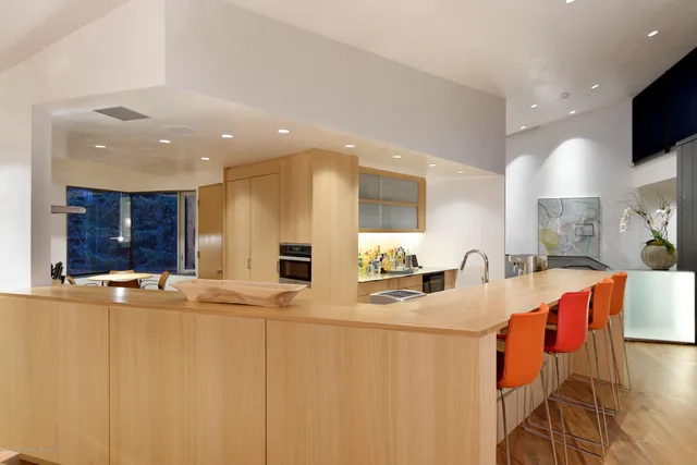 a kitchen with stainless steel appliances kitchen island granite countertop a sink and a refrigerator
