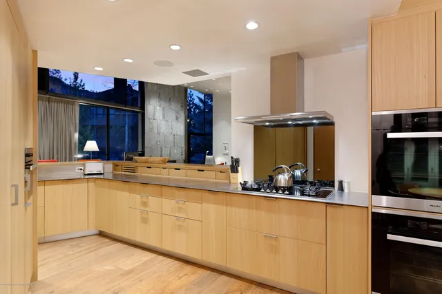 a large kitchen with stainless steel appliances a sink and cabinets