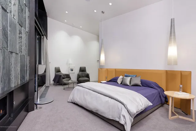 a bedroom with bed and a flat tv screen on dresser