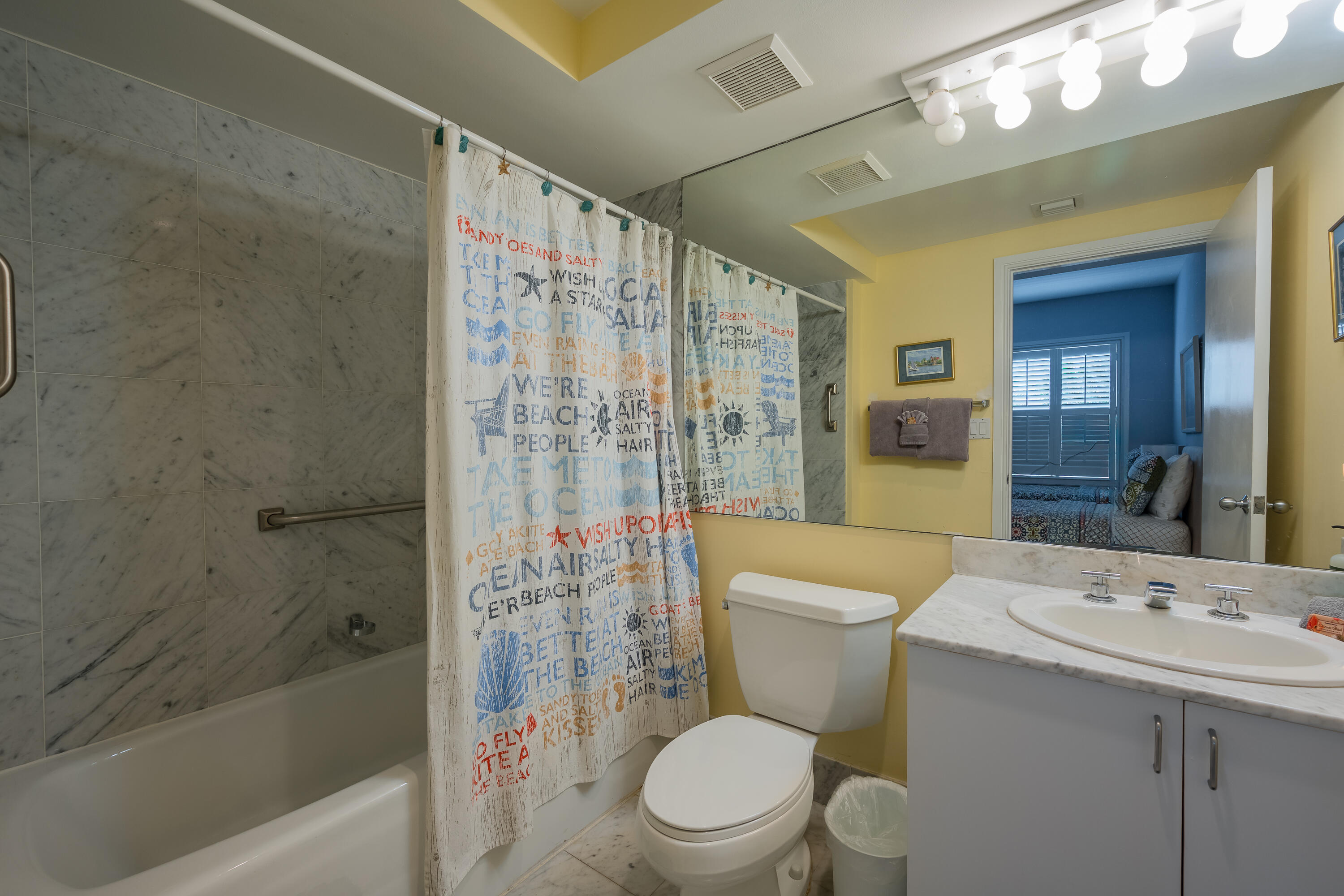105 Front Street, Unit 119 Key West, FL 33040 - Photo 14 of 18 a bathroom with a sink a toilet a mirror a bathtub and shower