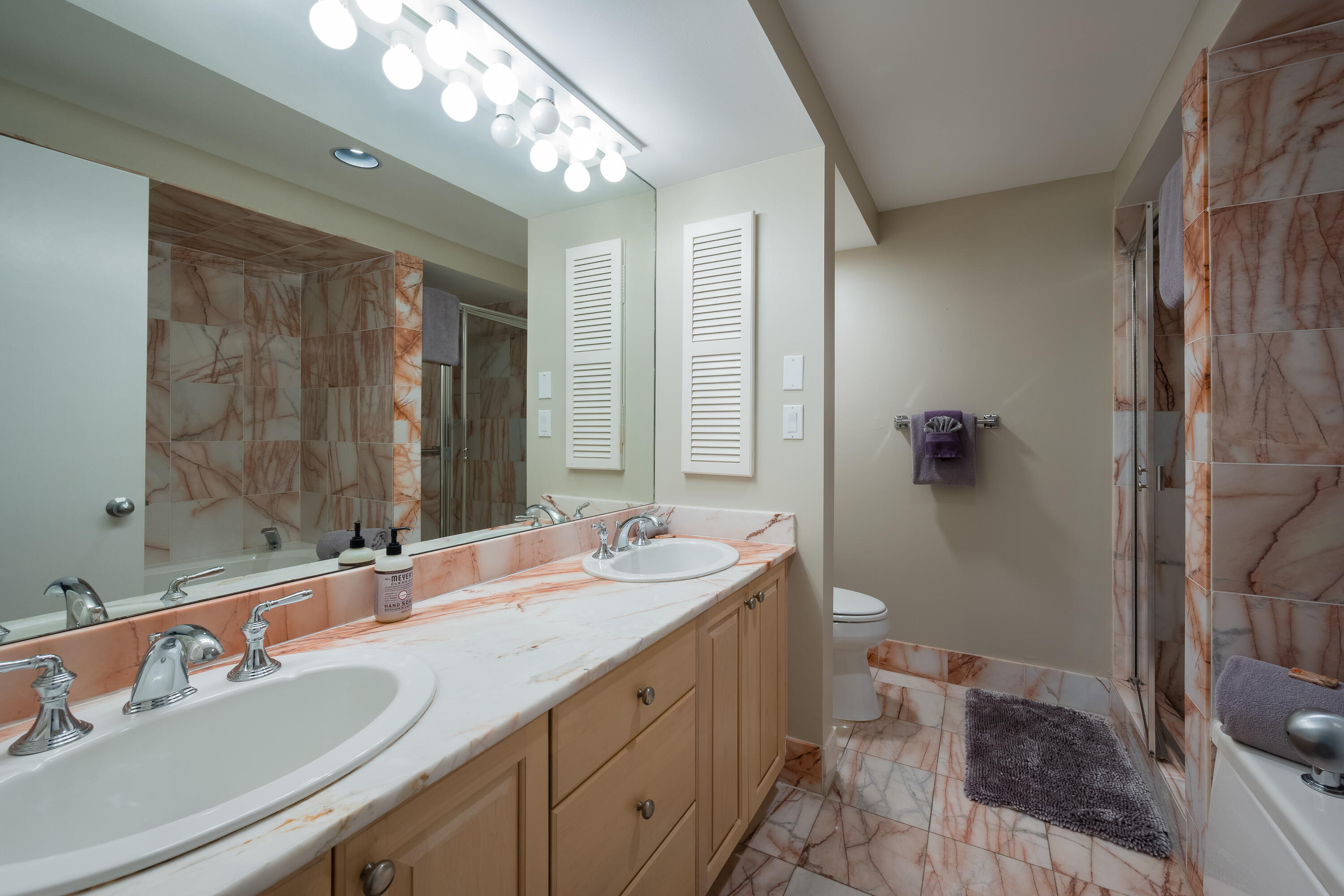 105 Front Street, Unit 119 Key West, FL 33040 - Photo 10 of 18 a bathroom with a double vanity sink toilet and shower