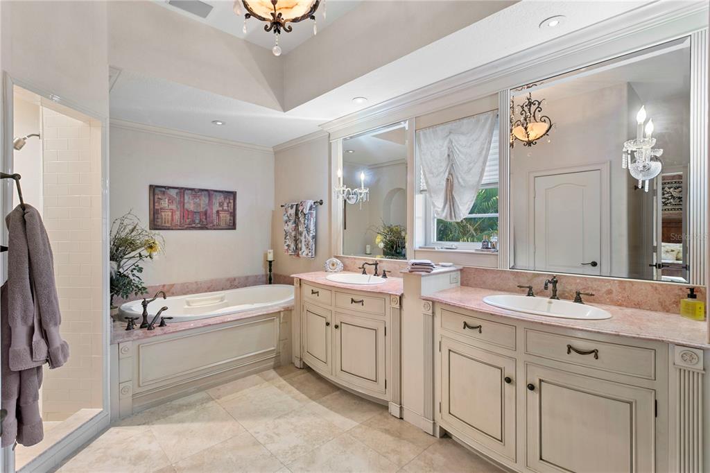 4803 West Woodmere Road Tampa, FL 33609 - Photo 39 of 80 a bathroom with a double vanity sink a mirror a bathtub and a shower