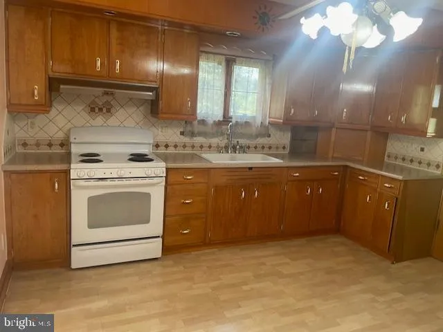 a kitchen with a stove sink and cabinets