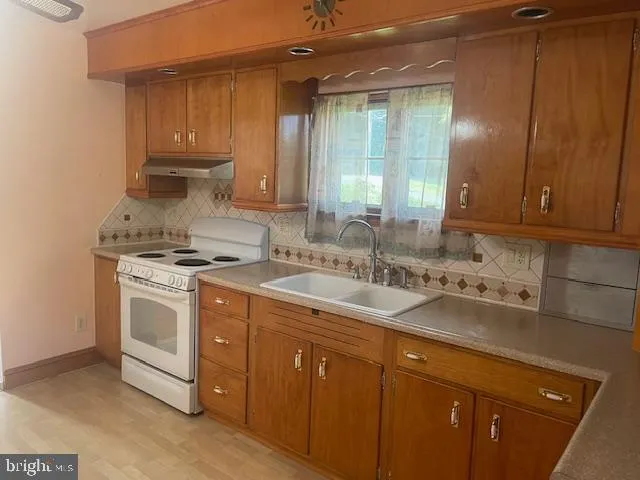a kitchen with stainless steel appliances granite countertop a sink stove and cabinets